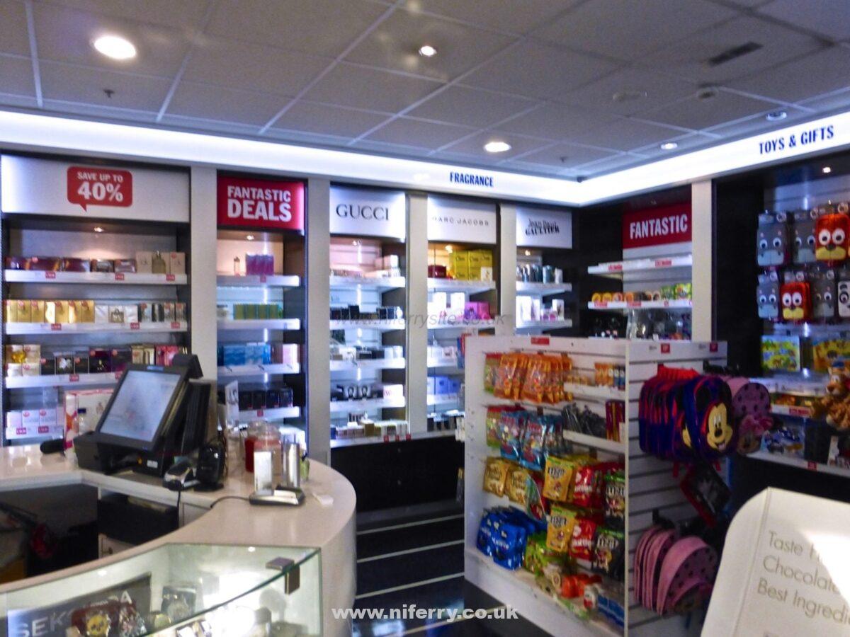 A view showing part of the onboard shop. The shop sells a selection of items including but not limited to Fragrances (some good deals when I was onboard), sweets, souvenirs and gifts, and travel essentials. The member of crew manning the shop seemed very knowledgable and keen to offer assistance in choosing fragrances. © NIFerrySite
