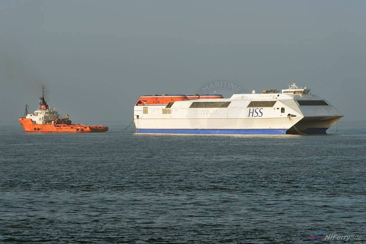 One World Karadeniz, the former Stena Explorer, leaves Holyhead under the tow of Bluster.  This view is similar to that of Stena Voyager being towed from Belfast, also stern first, by the tug Agat in 2013.  Copyright © Gary Davies/Maritime Photographic.